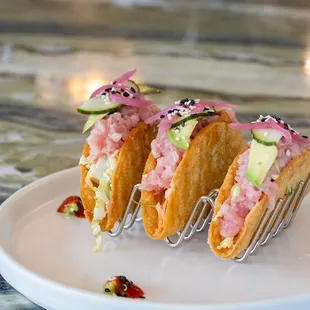 three tacos on a plate with a fork