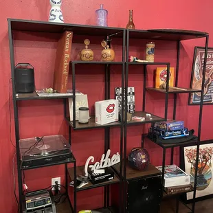 a red wall and shelves with various items