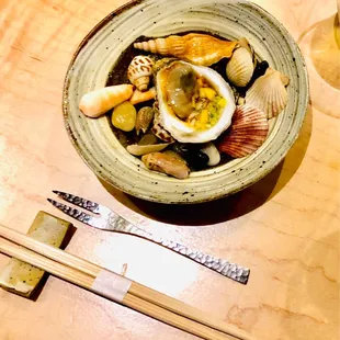 a bowl of food on a table with chopsticks