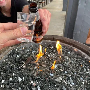 a man lighting a fire pit