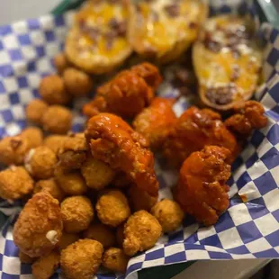a basket of chicken wings and tater tots