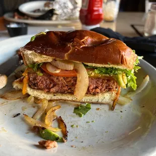 Bad Hunter vegan burger with sautéed onion, avocado, cheddar cheese, lettuce and tomato