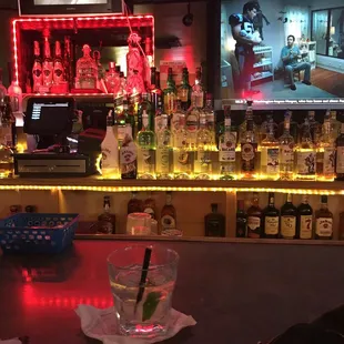 a bar with liquor bottles and a television in the background