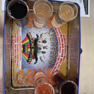 a tray of beer glasses and a menu