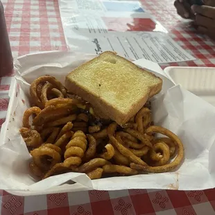 Triple cheeseburger burger with onion rings, bacon , and BBQ sauce. With some curly fries