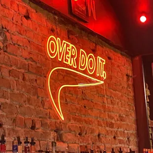 a brick wall with a neon sign