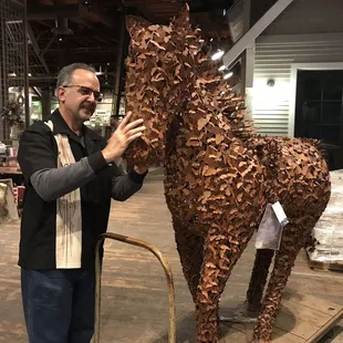 a man standing next to a sculpture of a horse