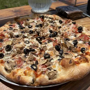 Small pizza with mushrooms, olives and Italian sausage