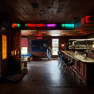 a dimly lit bar with stools
