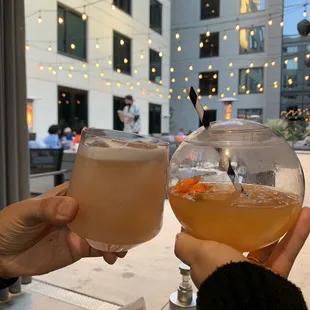 two people toasting drinks