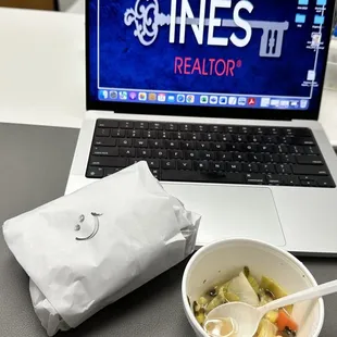 a laptop and a bowl of food