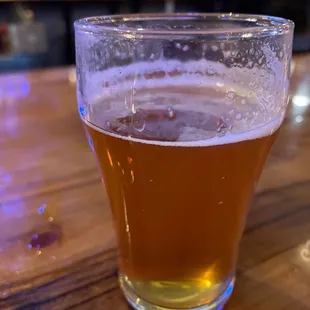 a glass of beer on a bar