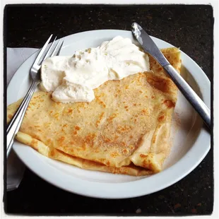a plate of crepes with whipped cream