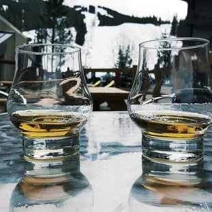 two glasses of whiskey on a table