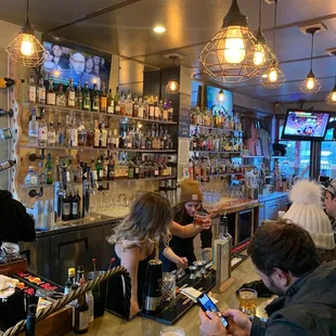 people sitting at a bar and looking at their cell phones