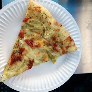 White pizza topped with sun dried tomato, artichoke, onions, and goat cheese
