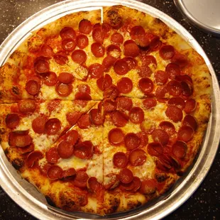 a pepperoni pizza on a pan