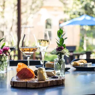 a table with wine glasses and cheeses