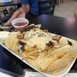 a plate of nachos with a side of salsa