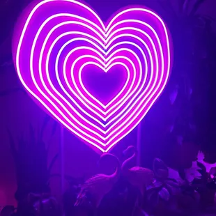 a heart shaped neon sign in a dark room