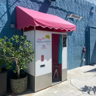 a small store with a pink awning
