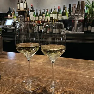 two glasses of wine on a bar