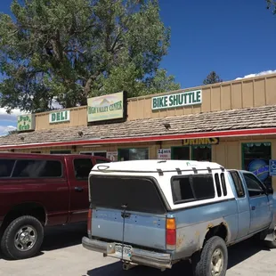 two vehicles parked in front of a store