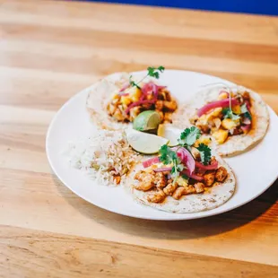 three tacos on a white plate