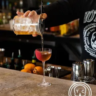 a bartender pouring a drink at a bar