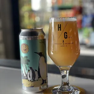 a glass of beer next to a can of beer