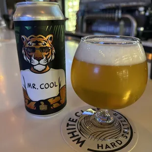 a glass of beer next to a can of beer