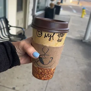 a hand holding a cup of coffee