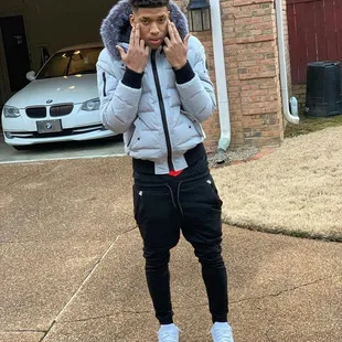 a man standing in front of a garage talking on a cell phone