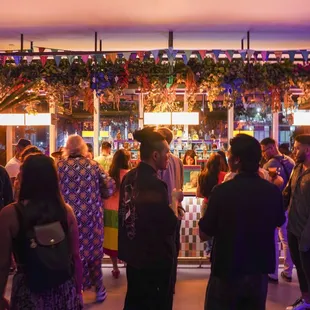 a group of people standing in front of a bar