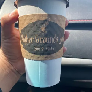 a hand holding a cup of coffee