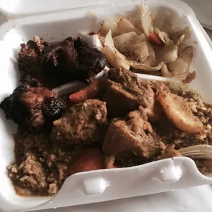 curry and jerk chicken combination plate with extra gravy. sides: cabbage and rice and peas.