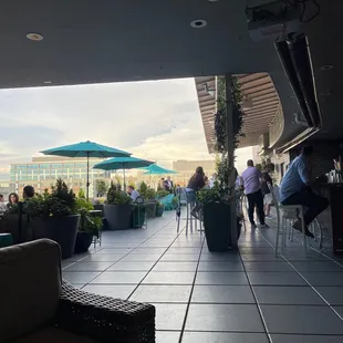 a view of a patio with tables, chairs, and umbrellas