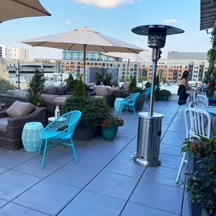 a patio with chairs, tables and umbrellas