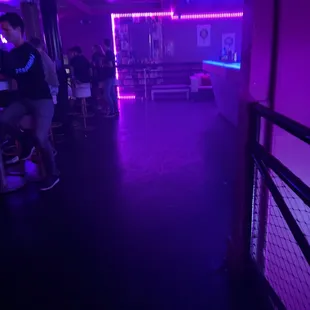 a man sitting at a bar with purple lights