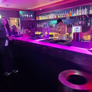 a man and a woman standing at a bar