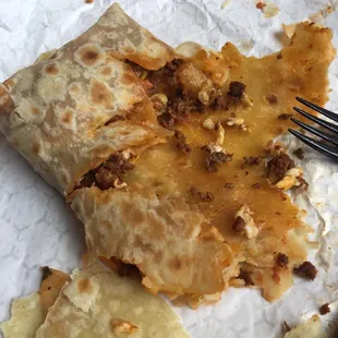 a partially eaten burrito and a fork