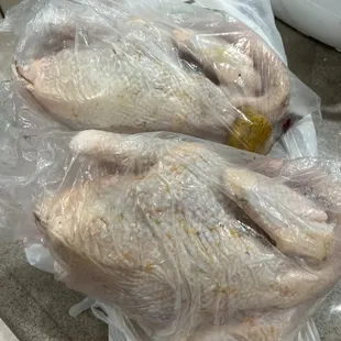 two whole chickens wrapped in plastic