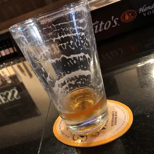 a glass of beer on a coaster