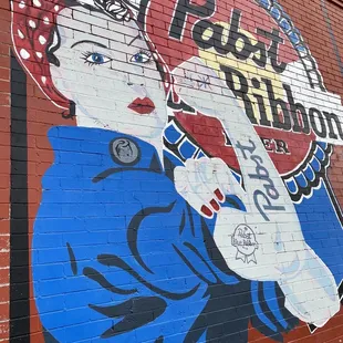 a mural of a woman drinking a soda