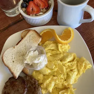 Sausage patties and eggs with a side of yogurt parfait.