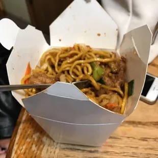 a take out box of noodles
