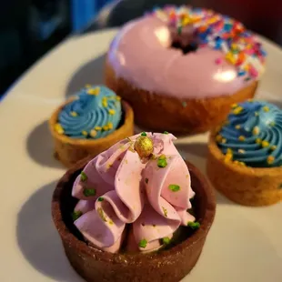 a plate of cupcakes with frosting and sprinkles