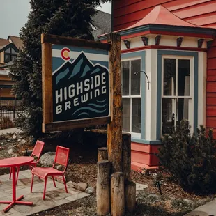 a red table and chairs in front of a red building