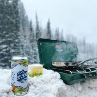 a can of frisbees and a can of beer in the snow