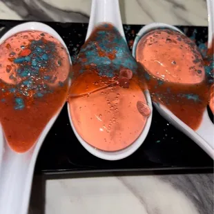 three spoons with liquid in them